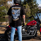 Man standing next to his Harley Davidson motorcycle wearing an Omenz Liberty unisex t-shirt
