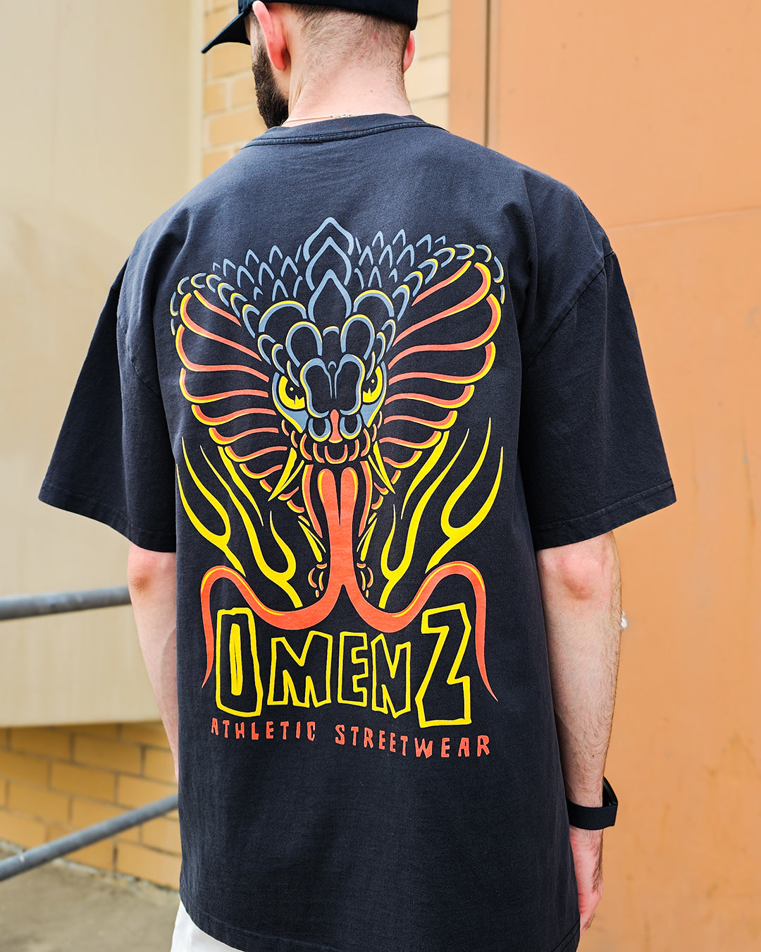 Omenz alternative athletic streetwear Rival Unisex Oversized Tee back view. In 100% cotton and faded black this premium t-shirt print is tattoo flash inspired art.