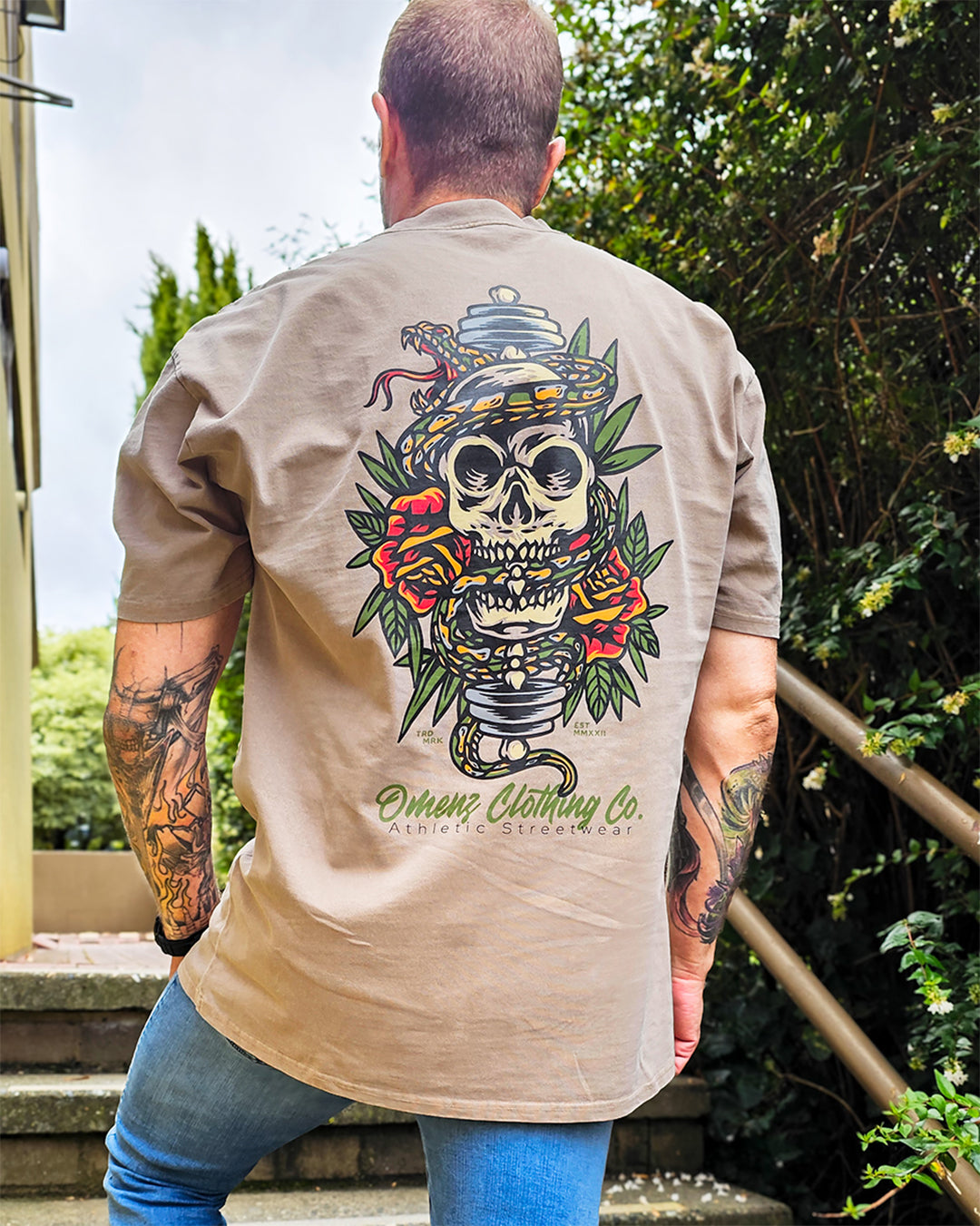 back view of the Omenz Alternative skate and tattoo inspired Athletic Streetwear Tee. Faded khaki and an Oversized fit.